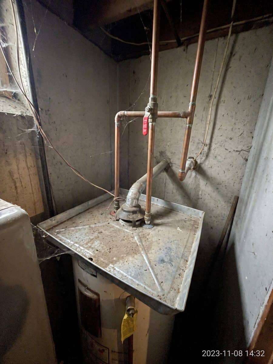 Chauffe-eau, conduites de cuivre et robinet d’arrêt dans un sous-sol